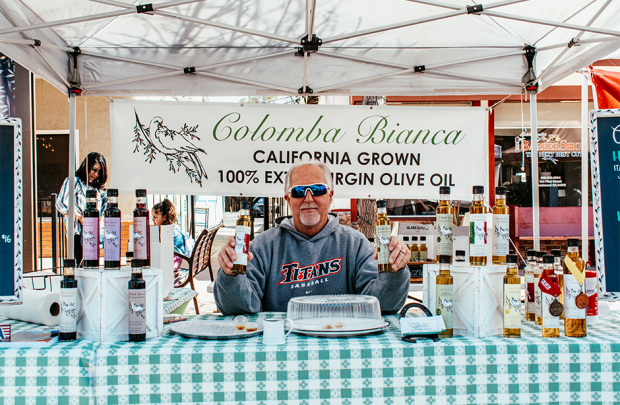 Picture of owner with products at farmers' market