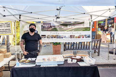 Worker at booth filled with cheeses