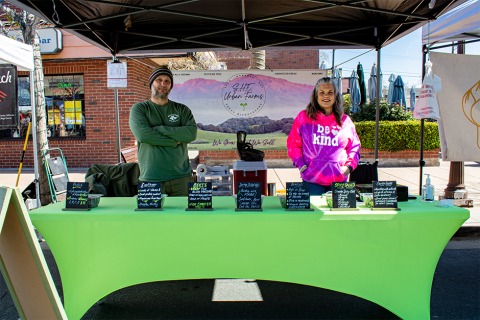 SHE Urban farms owners standing at their booth in the market