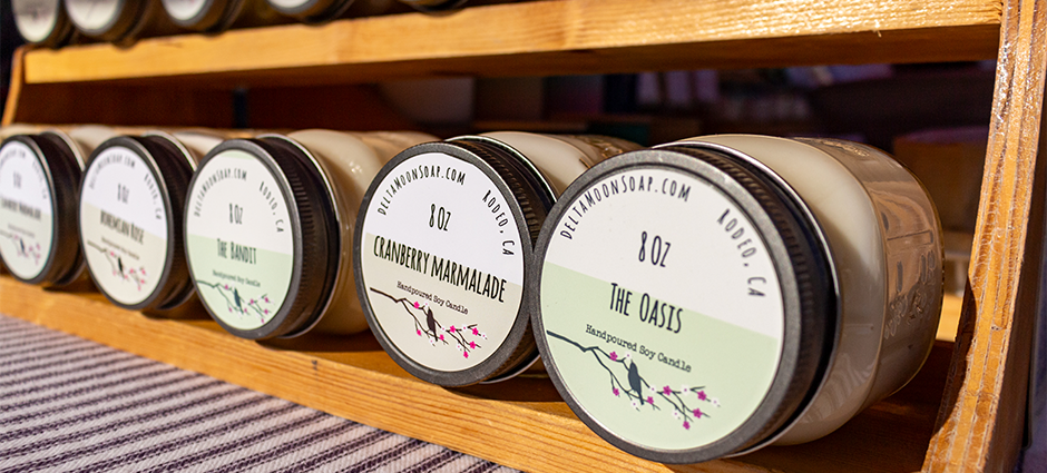 Candles sitting in a rack at the Delta Moon Soap booth