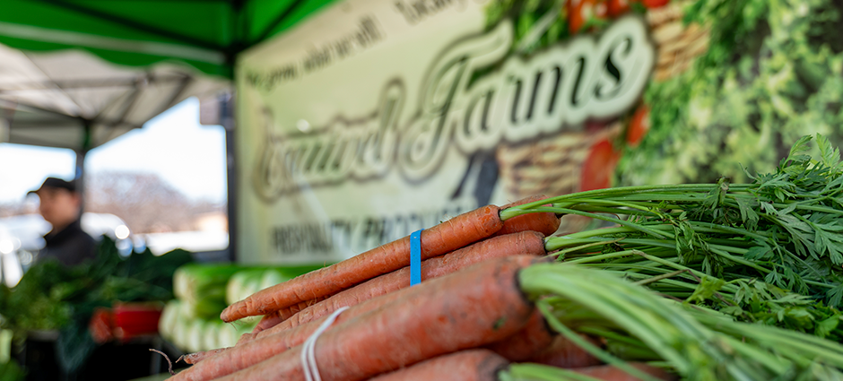 Carrots sitting in front of the sign at their booth