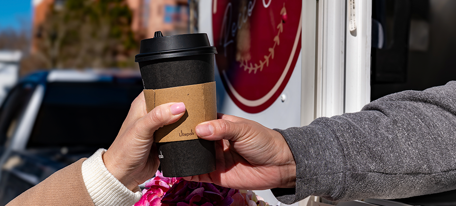 Coffe being handed from one person to another out the window of the Rocco Cafe trailer